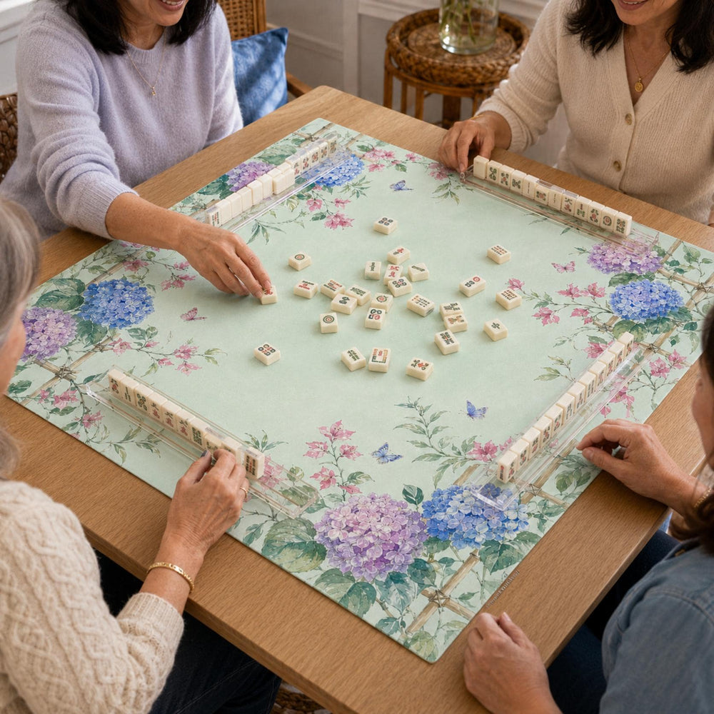 Blue and purple hydrangeas climb a trellis-style border around the pale green playing area of this floral Mahjong mat.