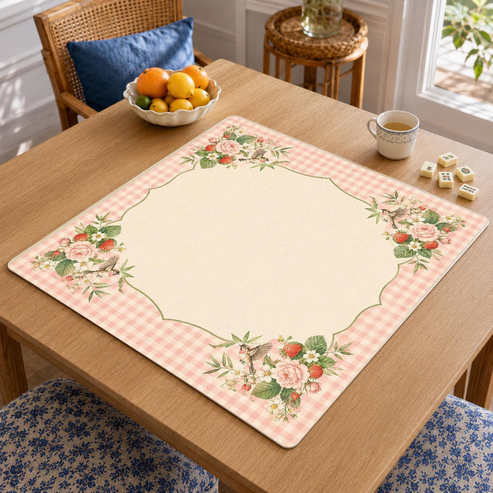 Strawberries and small flowers decorate a pink gingham border around the cream center of this cottagecore Mahjong mat.