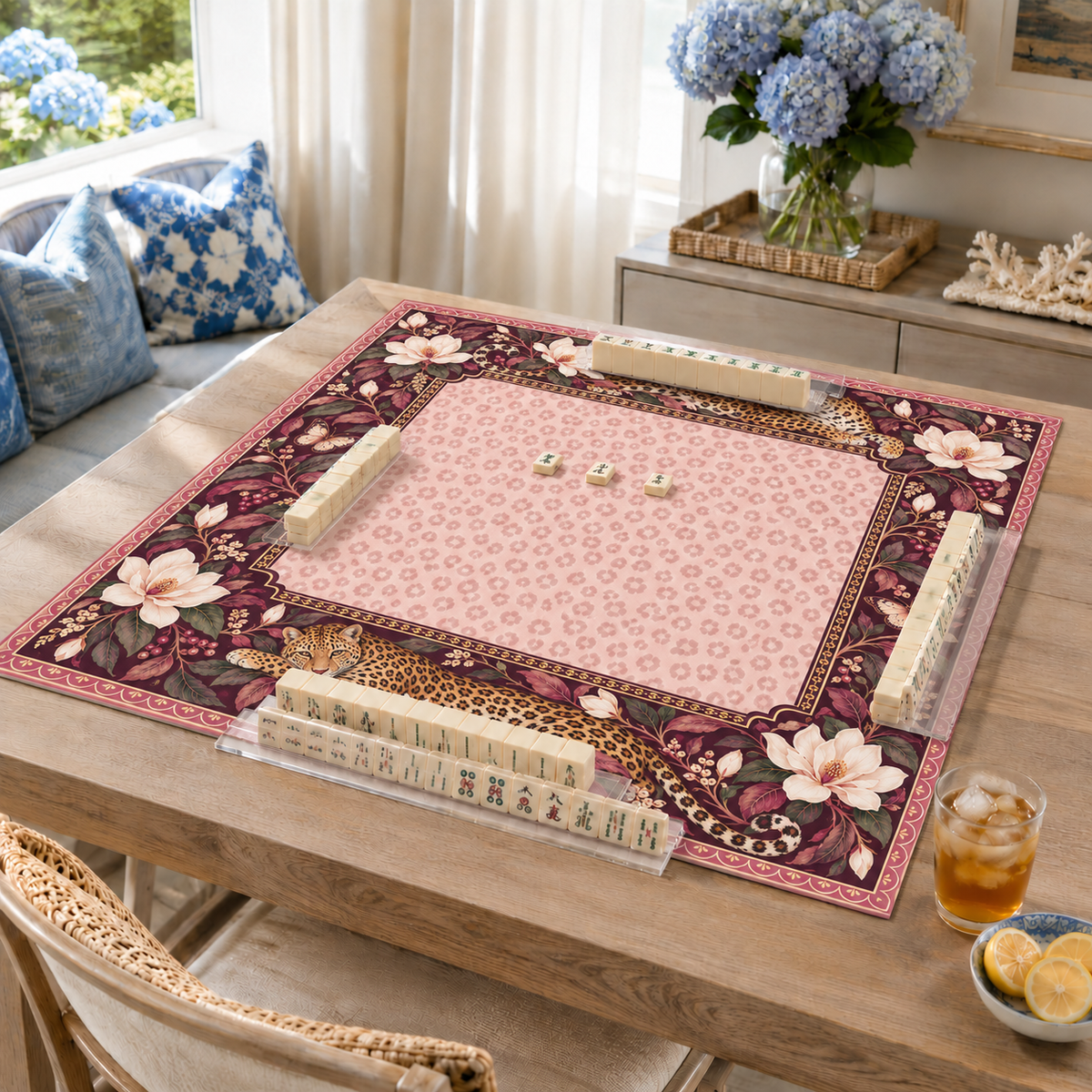 Burgundy vegan leather Mahjong mat with leopards and cream magnolias on a living room table