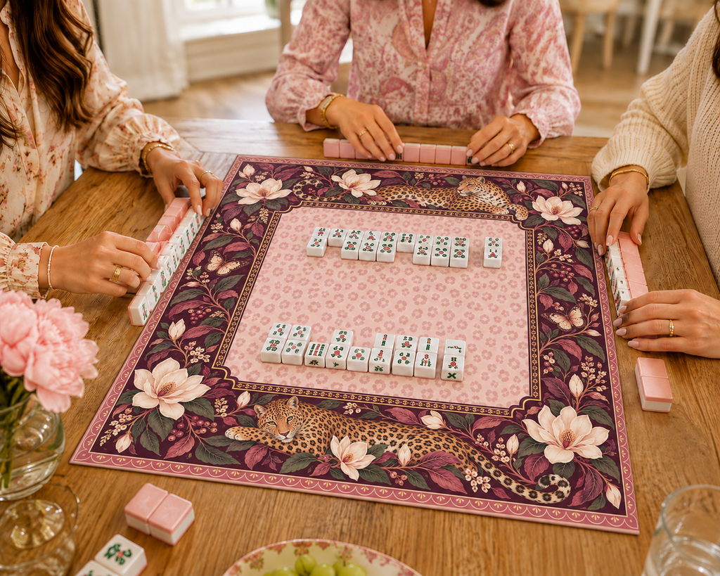 Burgundy vegan leather Mahjong mat with leopards and cream magnolias with Mahjong tiles during play