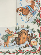 Cream suede backing beside the winter animal Mahjong mat with a scarf-wearing rabbit, gifts and a snowy wooden door