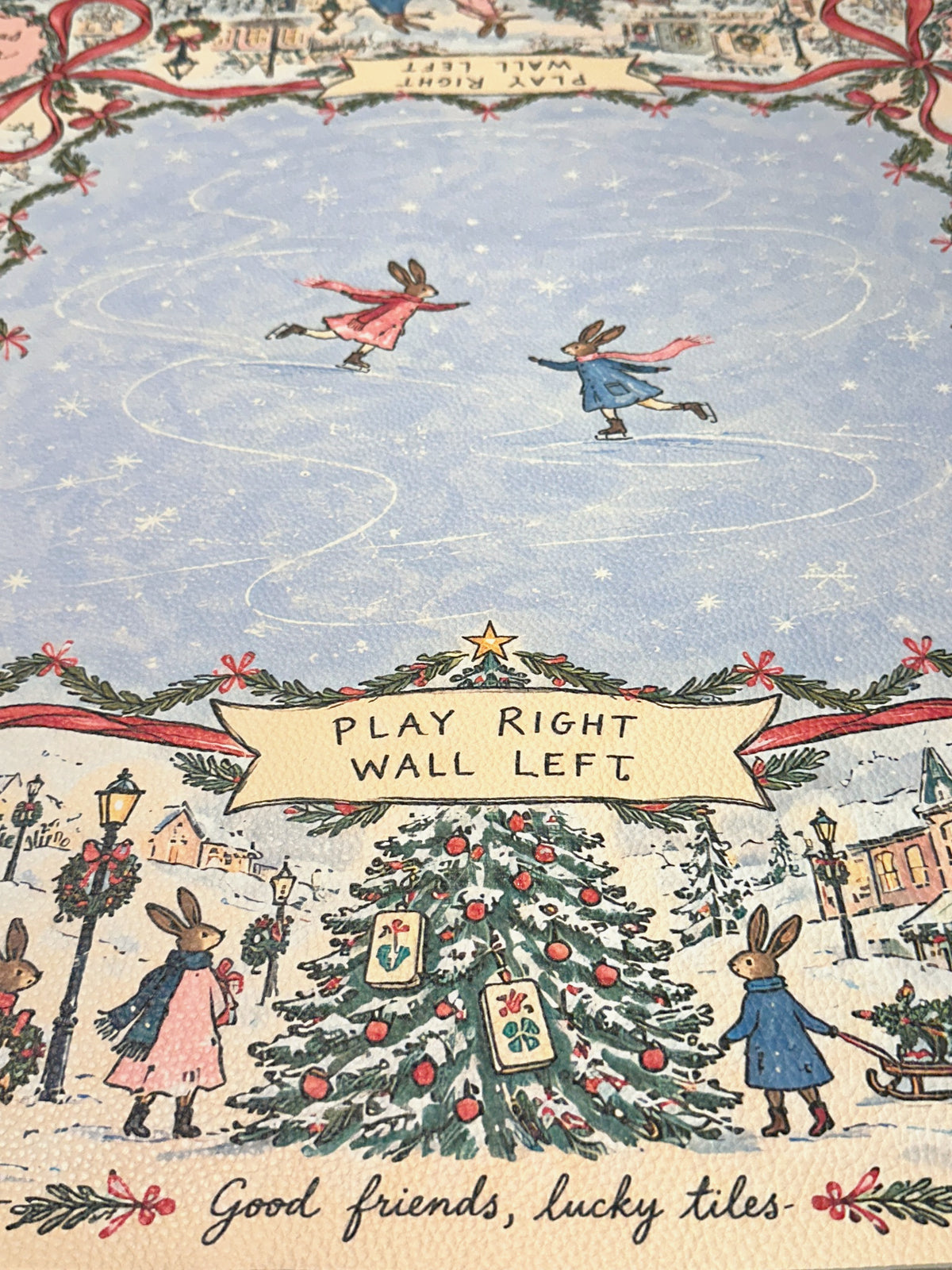 Close-up of skating rabbits and a Christmas tree beneath a Play Right Wall Left banner on the winter rabbit mat