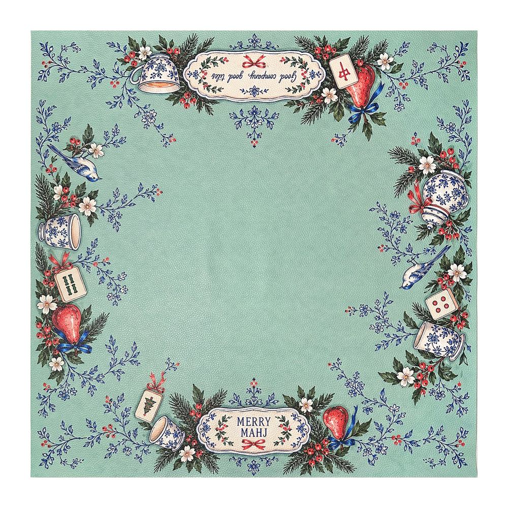Green Christmas Mahjong mat with Merry Mahj lettering, blue-and-white ceramics, red ornaments and festive greenery