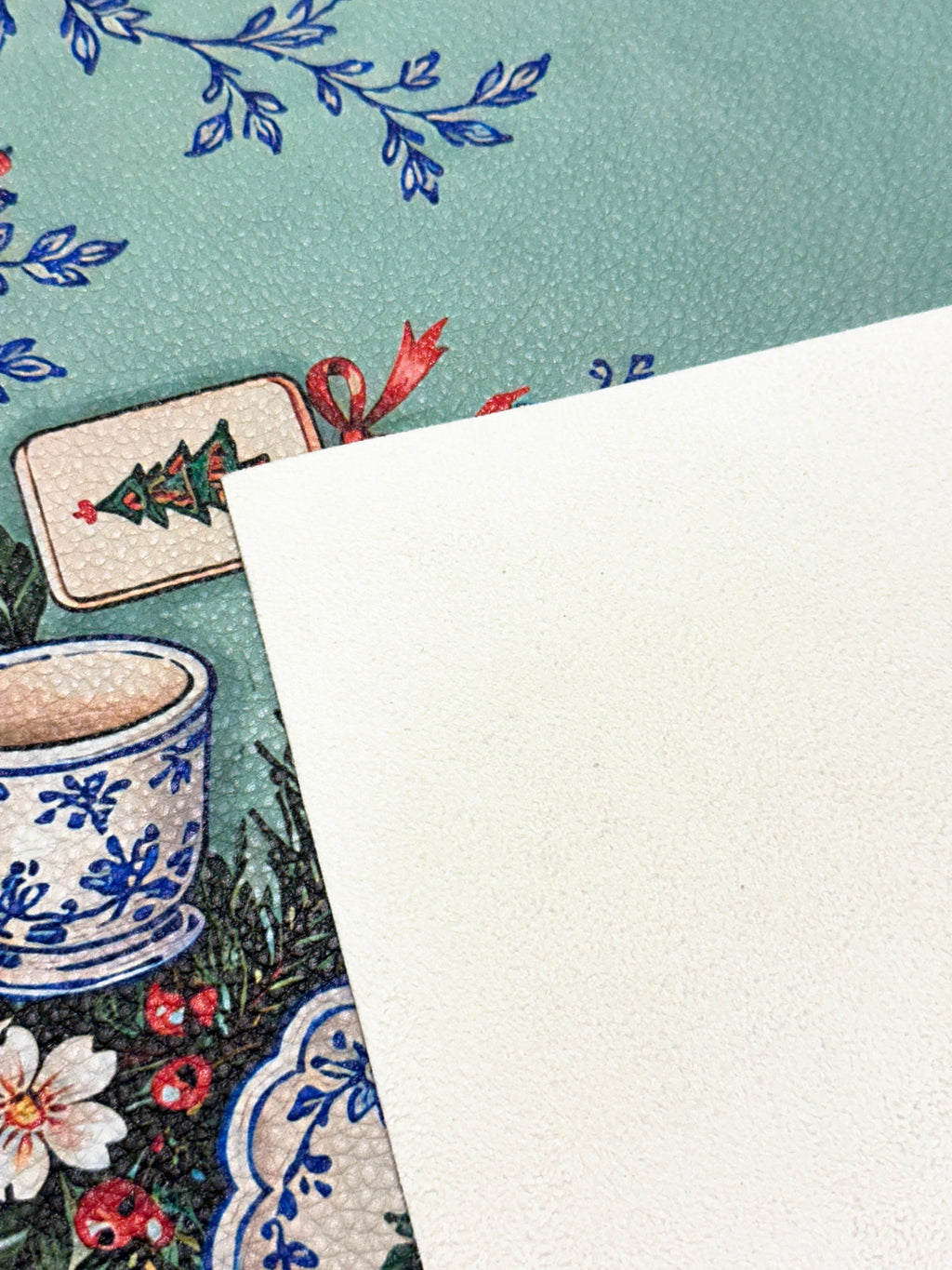Cream suede backing beside the printed green Merry Mahj mat with blue-and-white ceramic motifs