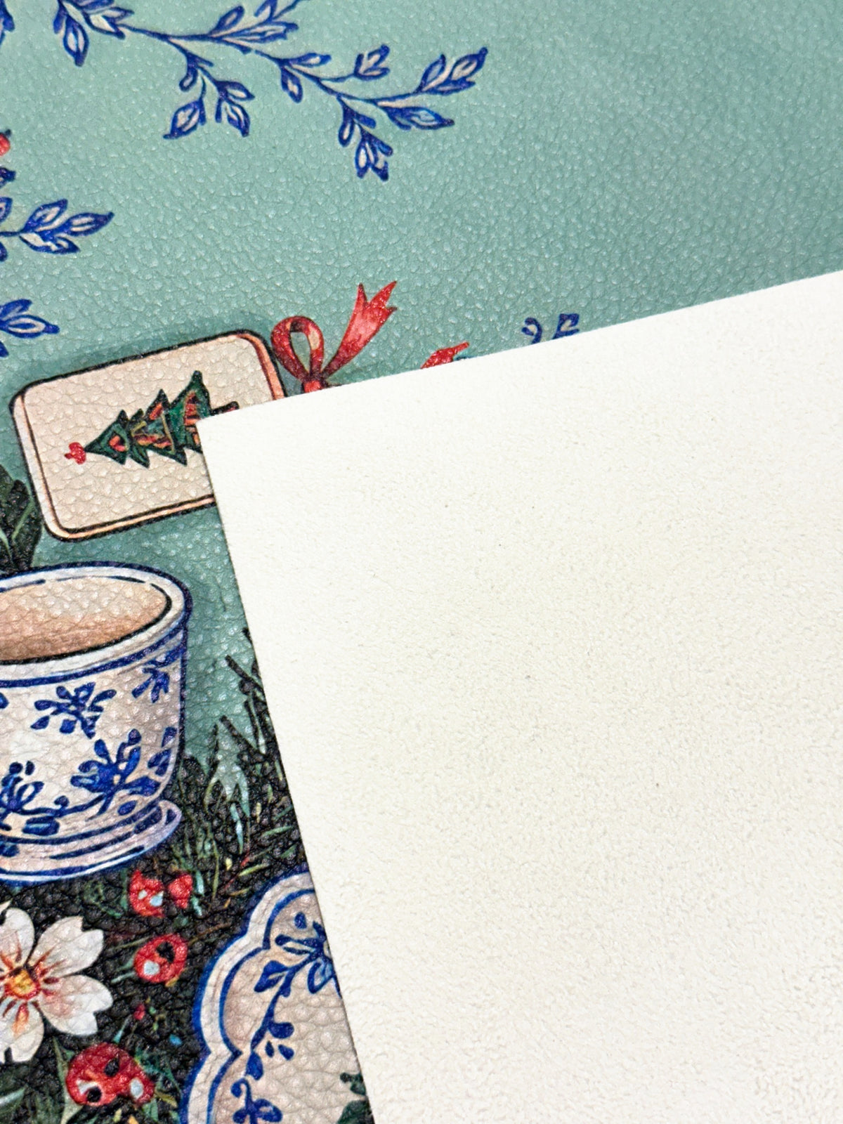 Cream suede backing beside the printed green Merry Mahj mat with blue-and-white ceramic motifs