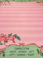 Close-up of printed Charleston passing reminders on the green border of the pink striped Christmas Mahjong mat