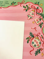 Cream suede backing beside the pink and green Christmas Mahjong mat with ornament, ribbon and Mahjong tile details