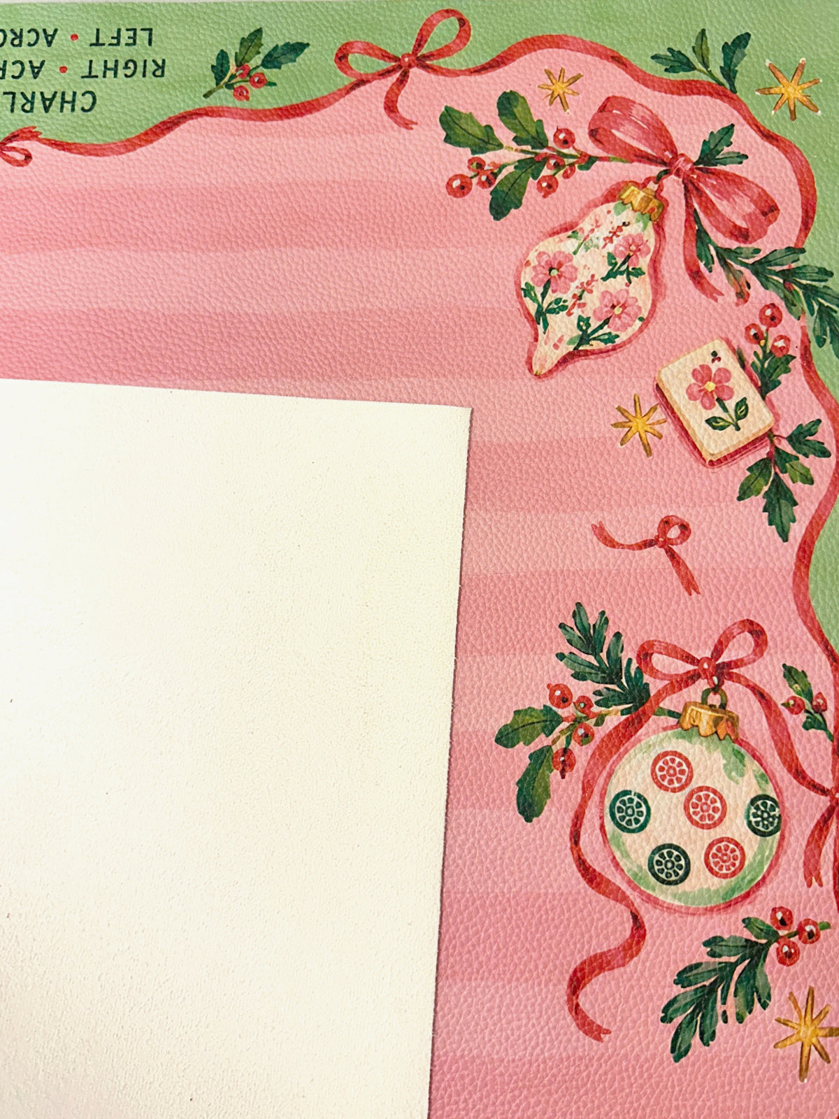 Cream suede backing beside the pink and green Christmas Mahjong mat with ornament, ribbon and Mahjong tile details