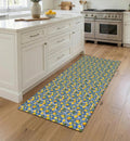 May include: A rectangular kitchen rug with a repeating pattern of yellow lemons and green leaves on a blue and white background. The rug is placed on a hardwood floor in front of a white kitchen island.