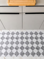 Gray and white marble checkered kitchen runner mat with a modern geometric pattern, displayed in a minimalist kitchen interior.