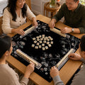 Pale birds, blossoms and branching stems stand out against the black background of this mother-of-pearl-inspired Mahjong mat.
