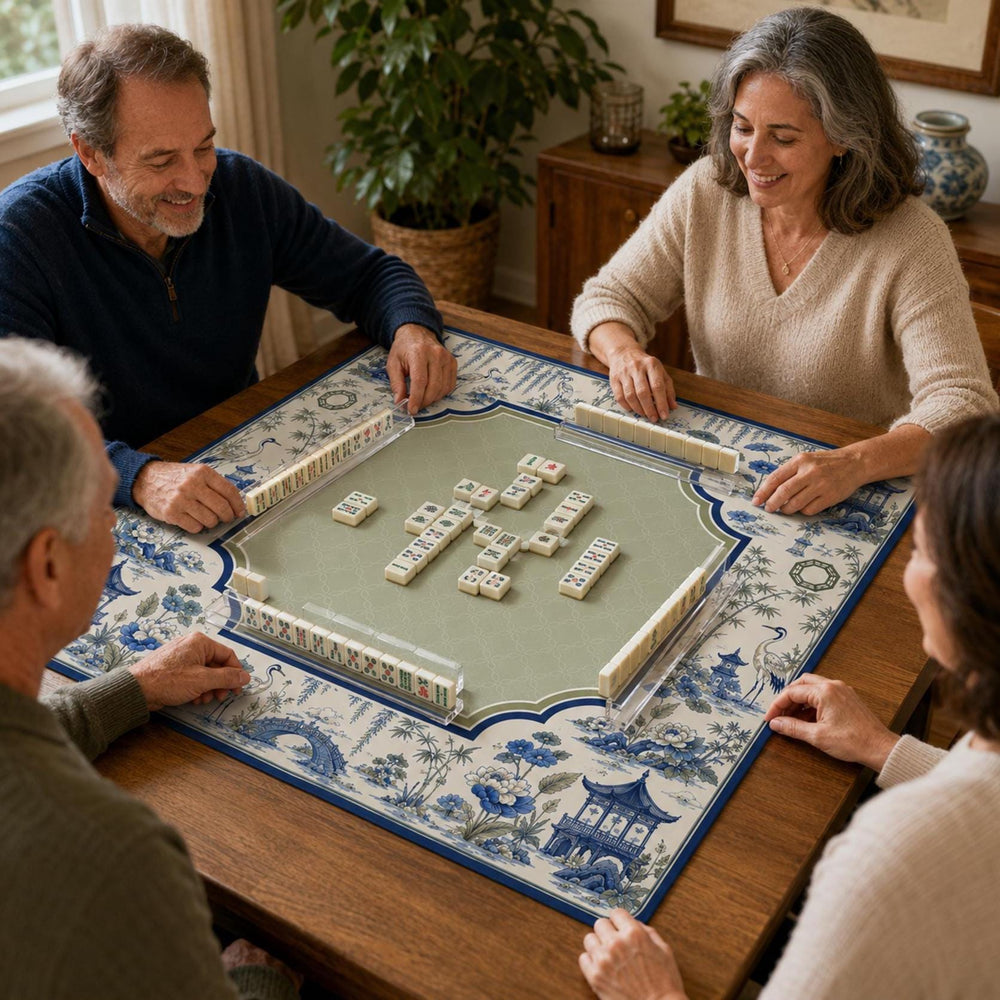 Blue cranes, pavilions and Willow-style landscapes form a scalloped border around the muted green center of this chinoiserie Mahjong mat.