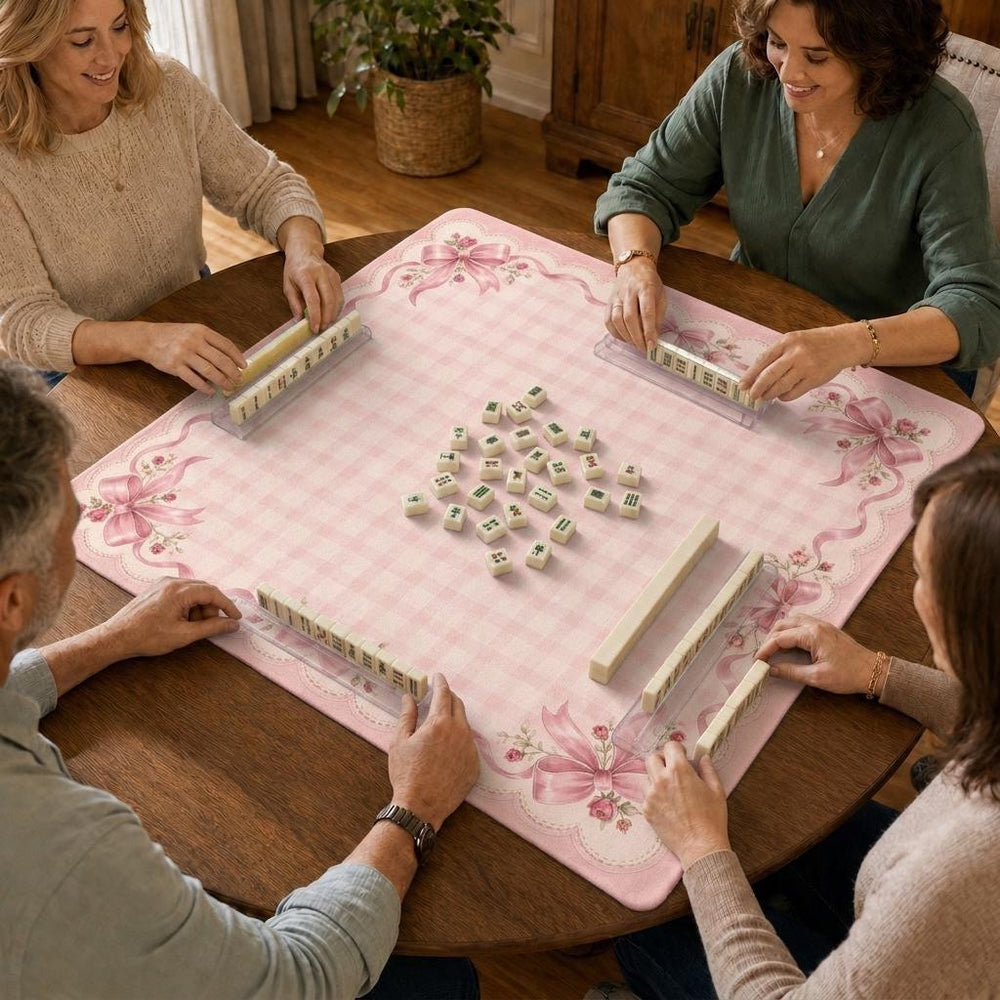 Soft pink gingham fills the playing area, while roses and ribbon bows decorate the corners of this coquette Mahjong mat.