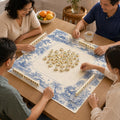 Blue pavilions, trees and landscape scenes create a toile-style border around the pale center of this Willow Pavilion Mahjong mat.