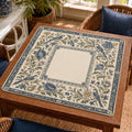 Blue songbirds and leafy branches fill a Delft-inspired border around the cream square center of this Mahjong mat.