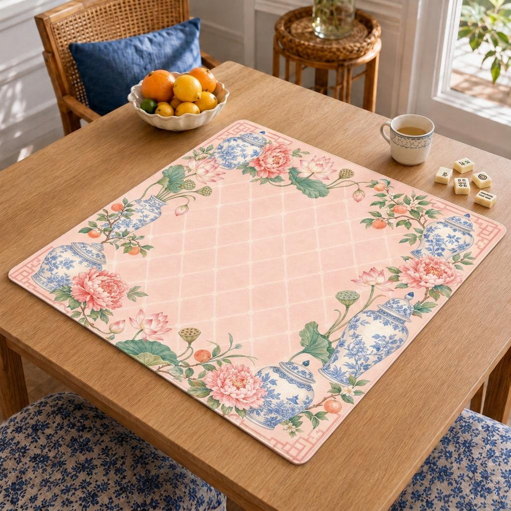 Blue-and-white ginger jars, lotus flowers and leafy details frame a blush pink lattice-patterned center on this chinoiserie Mahjong mat.
