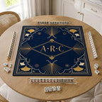 Gold-toned ginkgo and Art Deco lines frame personalized initials on a navy blue Mahjong mat.