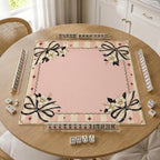 Large black-and-ivory bows, white flowers and fine stripes border a pink center on a coquette Mahjong mat.