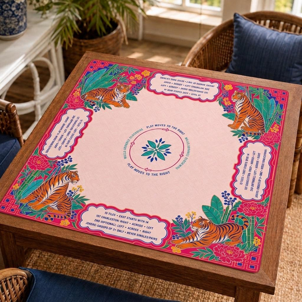Tigers and tropical foliage form a bright pink border around printed American Mahjong rules and a central Charleston guide on this Mahjong mat.