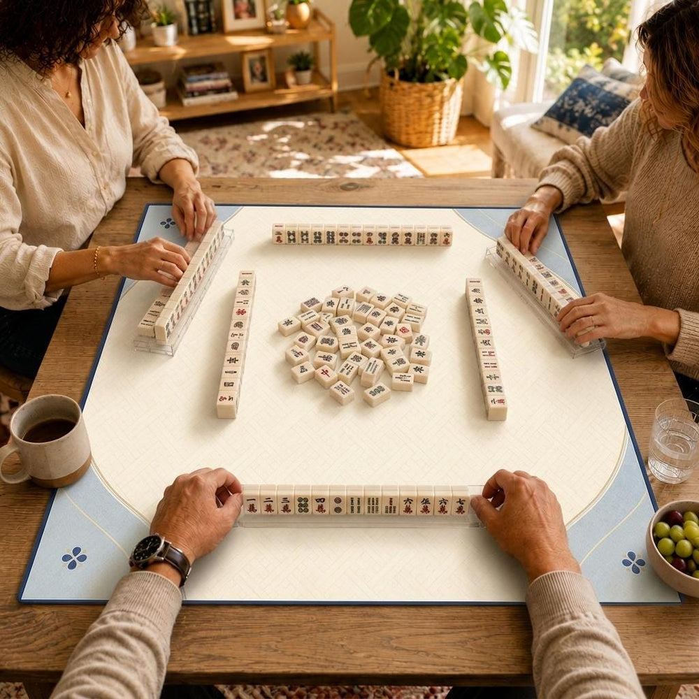 A fine blue outline and small botanical corner accents frame a spacious cream playing area on this minimalist Mahjong mat.