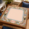 Christmas Mahjong mat with pink striped center, pastel nutcrackers, blue scalloped trim and ribbon bows on a wooden game table