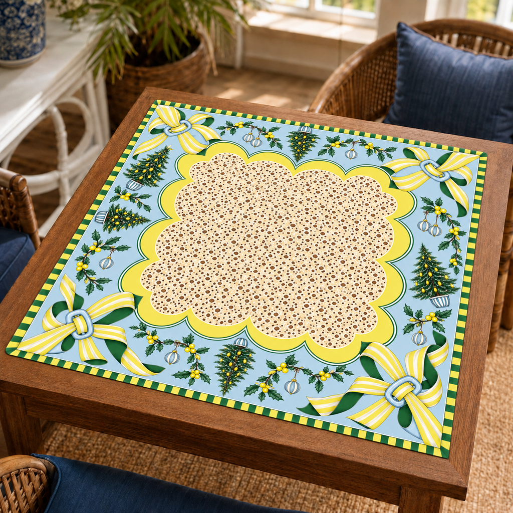 Christmas Mahjong mat with cream patterned center, pale blue border, yellow striped bows and Christmas trees on a wooden game table