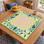 Angled table view of the Christmas Mahjong mat with cream patterned center, pale blue border, yellow striped bows and Christmas trees