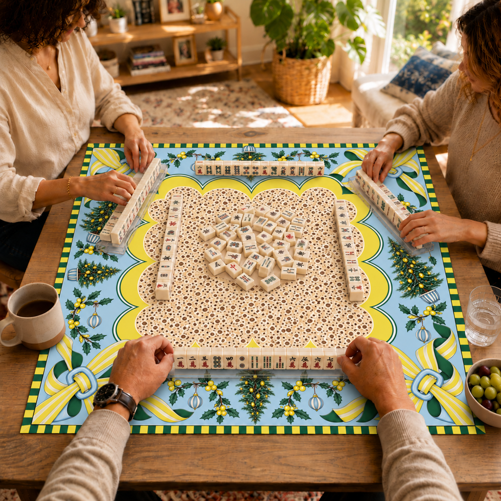 Mahjong game in progress on the Christmas mat with cream patterned center, pale blue border, yellow striped bows and Christmas trees