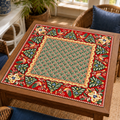 Christmas Mahjong mat with green geometric center, red folk art border, stylized birds and Christmas trees on a wooden game table