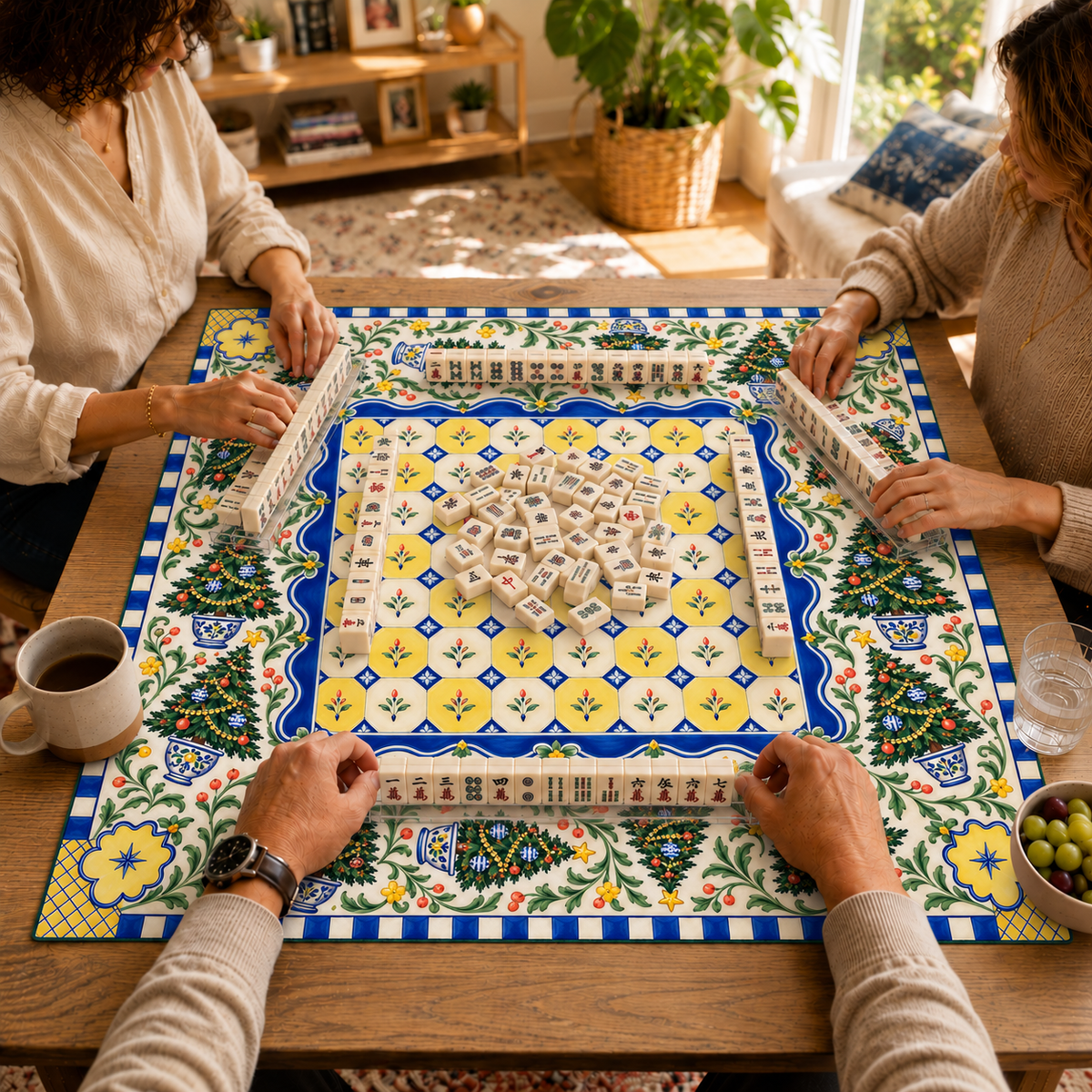 Mahjong game in progress on the Christmas mat with blue-and-yellow tile-style center, Christmas trees, leafy branches and floral corners